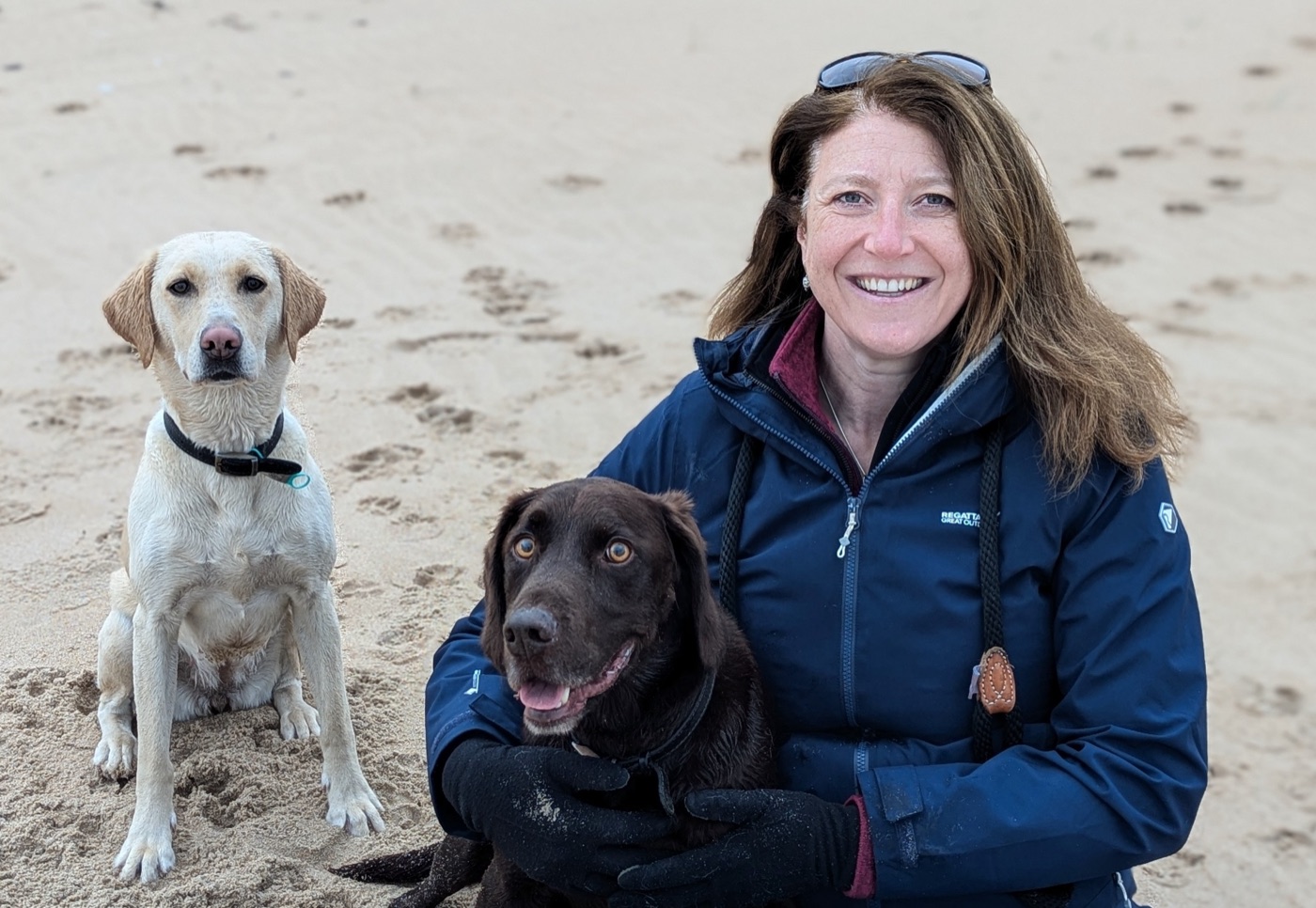 Claire on the beach with her two dogs